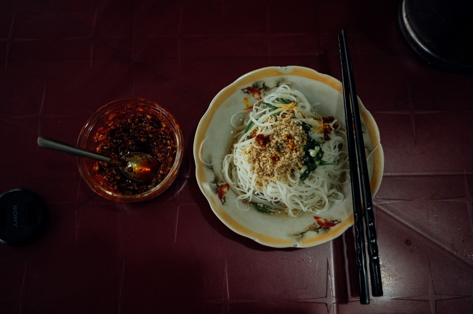 A refined plate of noodles accompanied by chopsticks, displayed on a table, highlighting fine dining etiquette.