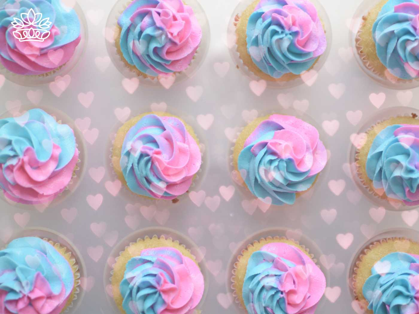 Cupcakes decorated with swirls of blue and pink icing arranged neatly with heart overlays, from the Gender Reveal Collection at Fabulous Flowers and Gifts.