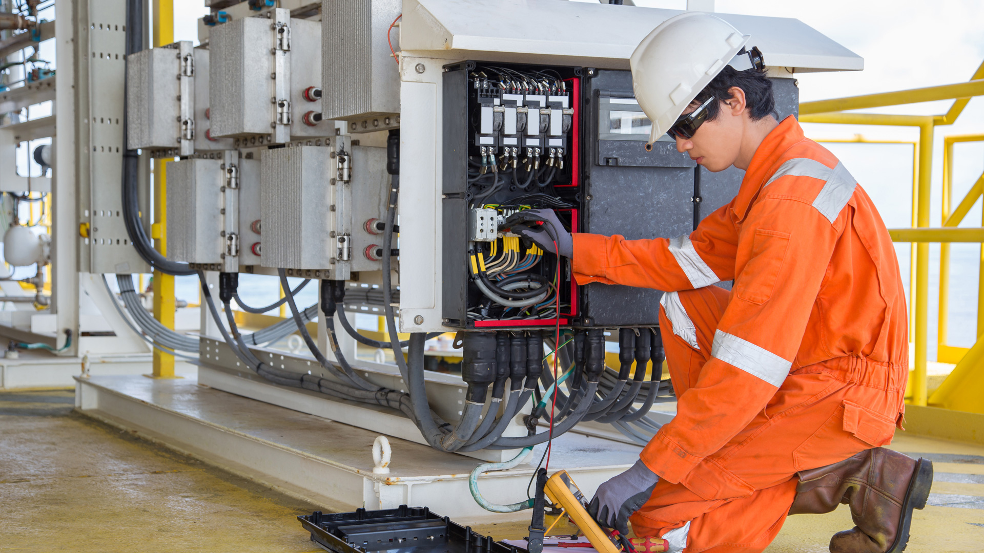 Oil and gas electrician working on electrical equipment