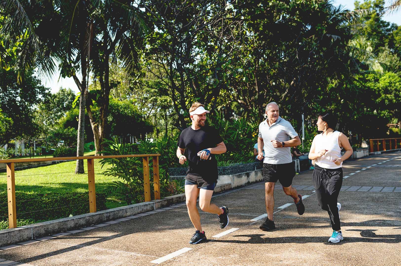 People jogging in a park promoting healthy living in Singapore.