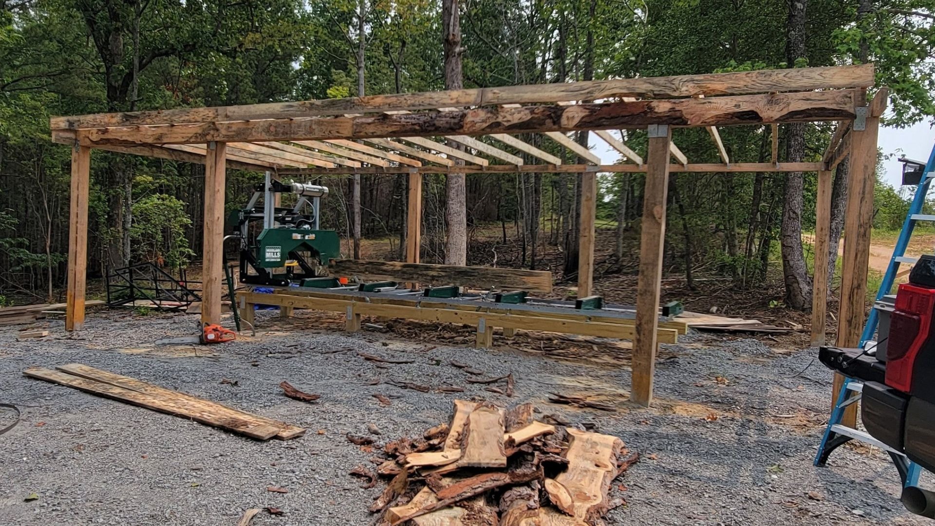 A timber frame shed mid-construction. The open side provides easy access for any log loading machines. 