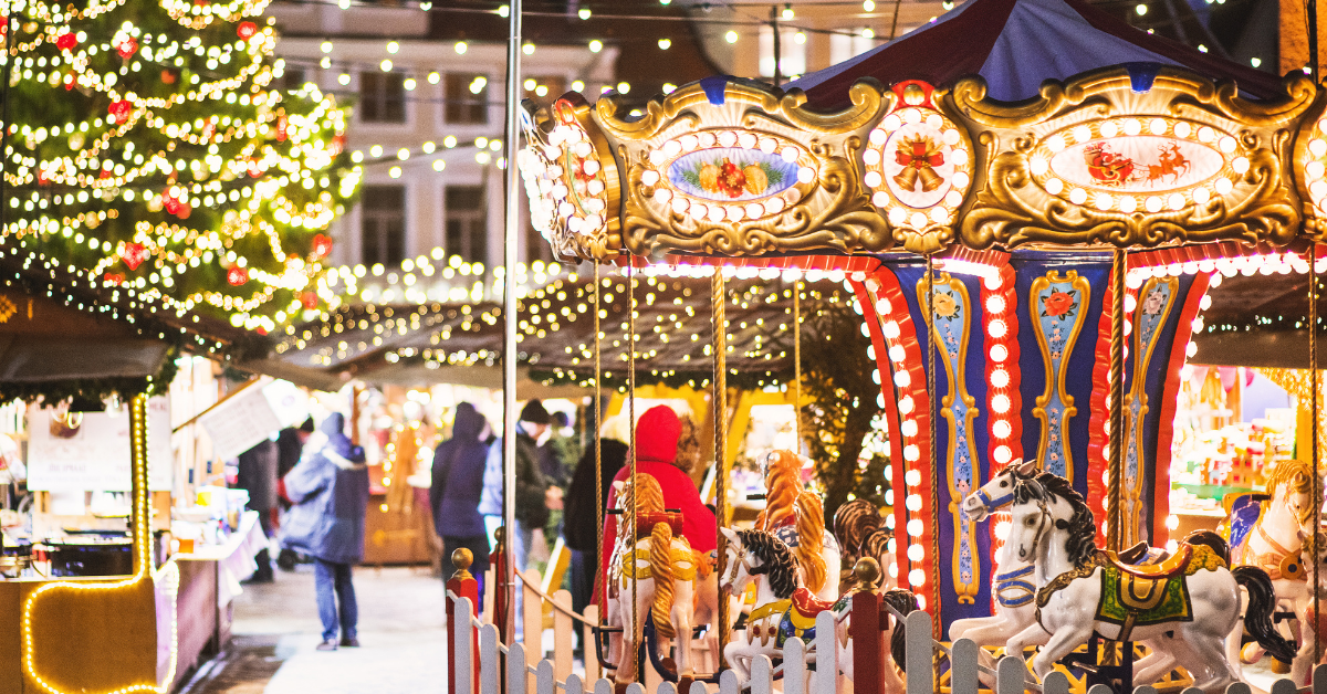 Enchanting Christmas village with a carousel, twinkling lights, and holiday market booths, representing festive winter wonderland celebrations and holiday events at the Jersey Shore.