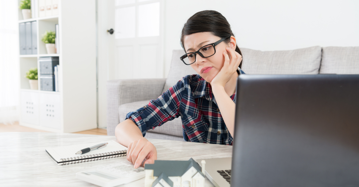 A woman uses a calculator and tax documents to figure out how to calculate home office deduction