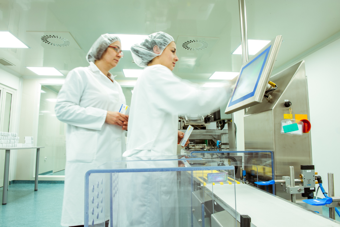 Technicians operating equipment inside a GMP-certified supplement manufacturing facility