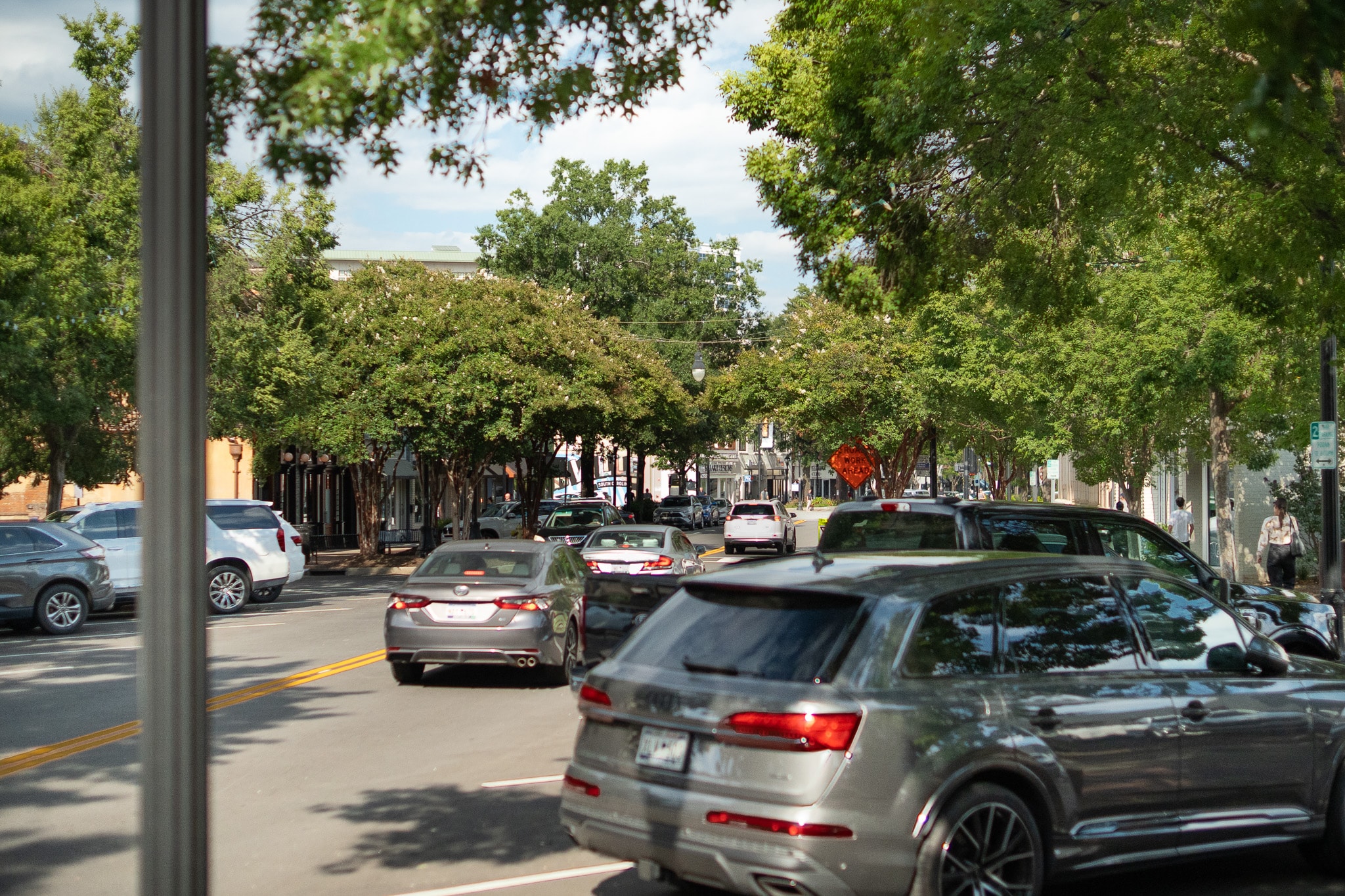 In a vibrant downtown Greenville street scene, historic buildings frame the area, while outdoor dining options invite families and residents to enjoy the local atmosphere. This charming part of Greenville, SC, offers a mix of shopping and dining experiences, making it a popular place to live and explore.