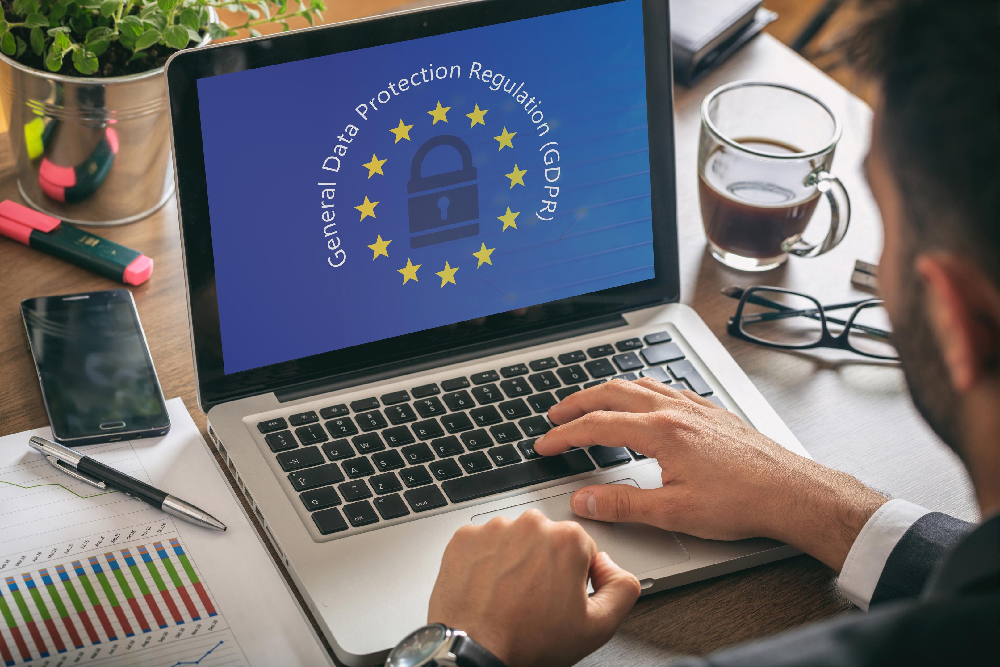 Homme travaillant avec un ordinateur, règlement général sur la protection des données et drapeau de l'Union européenne