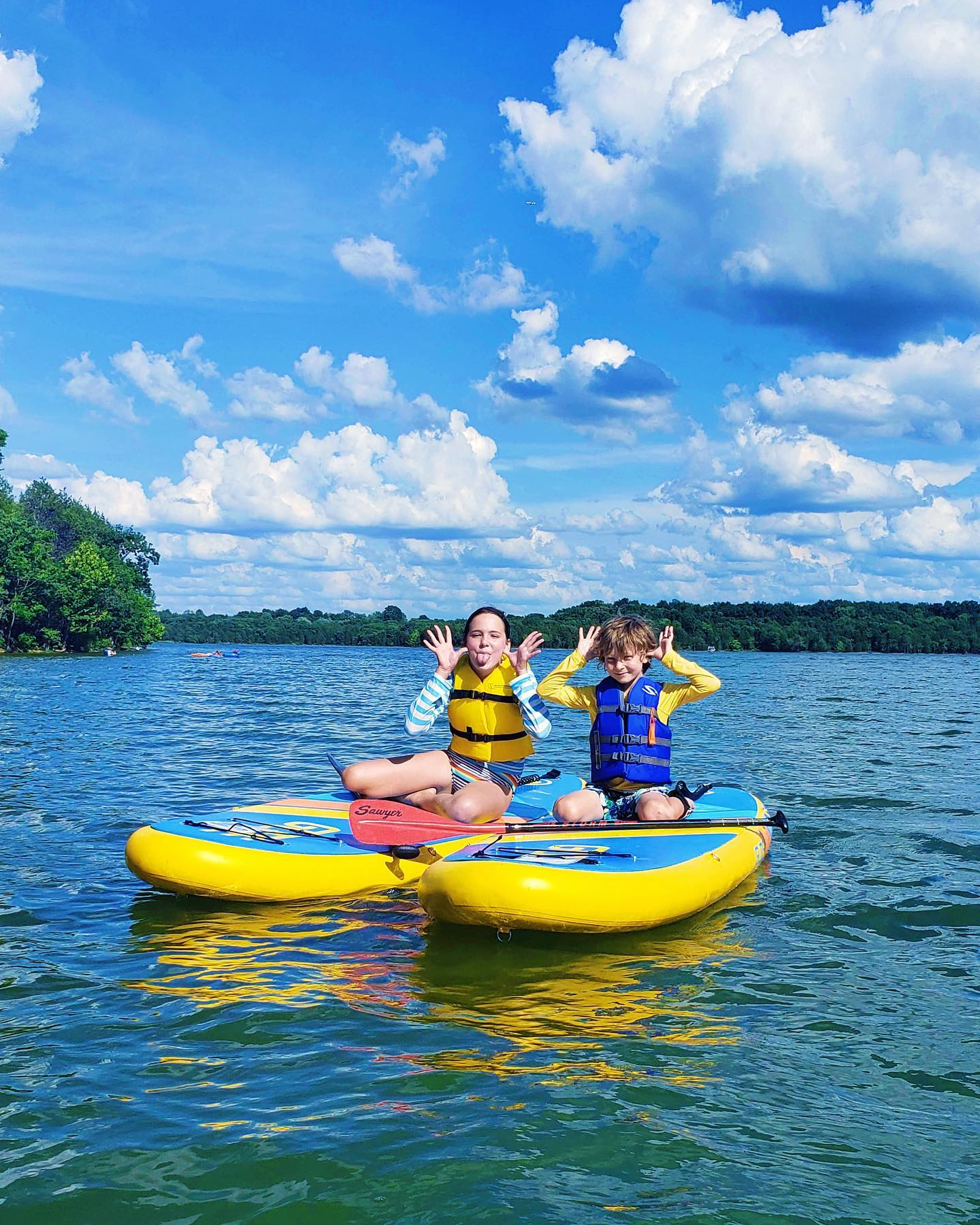 two kids on stand up paddle boards