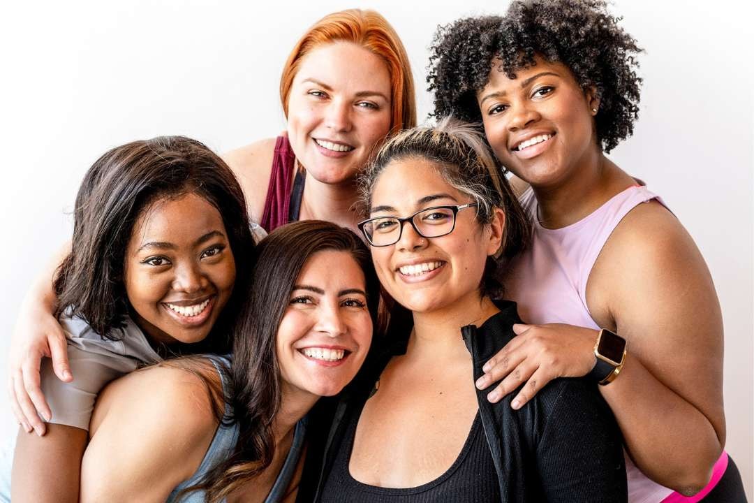 A group of diverse women smiling together, promoting health and supplements to boost immune system and overall wellbeing.