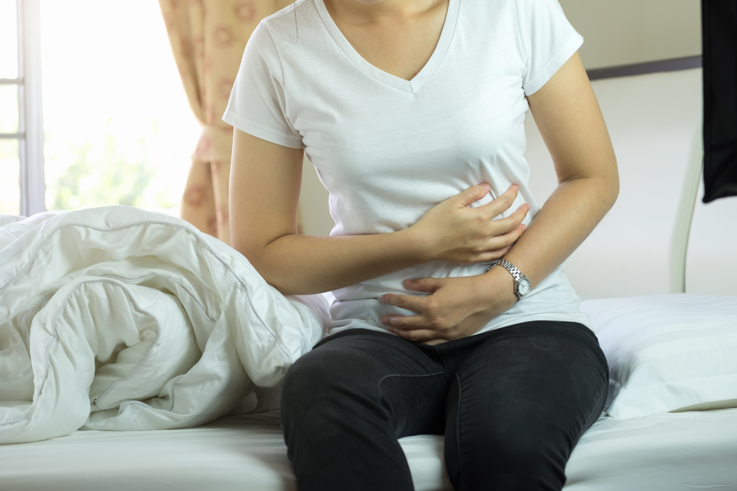 Person holding stomach in pain or discomfort.