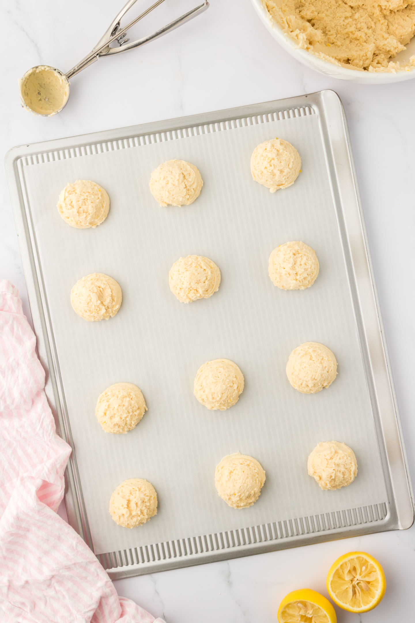 lemon cookie dough balls scooped onto a cookie sheet