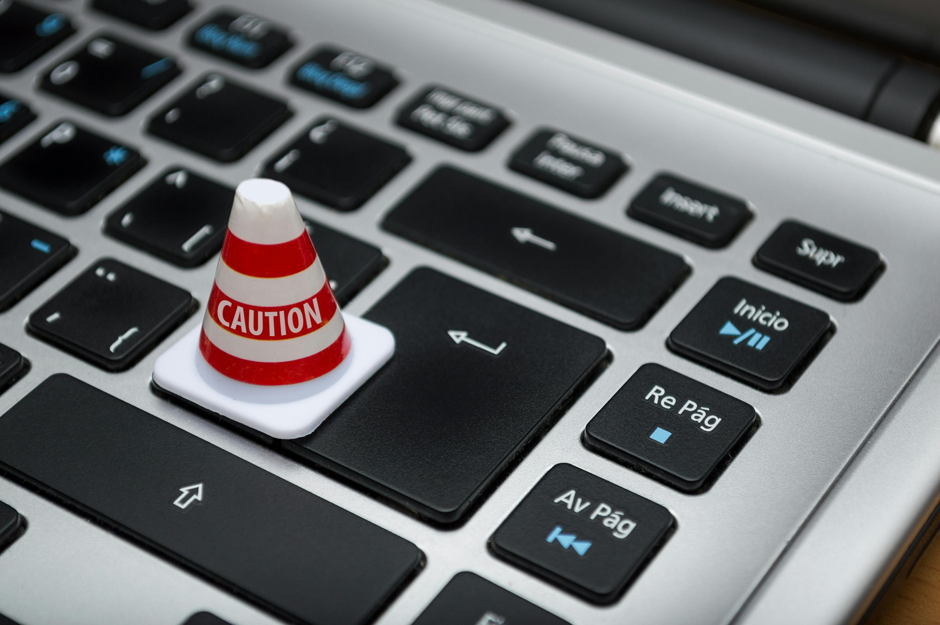 Mini caution cone on laptop signifying common mistakes made in marketing follow ups. 