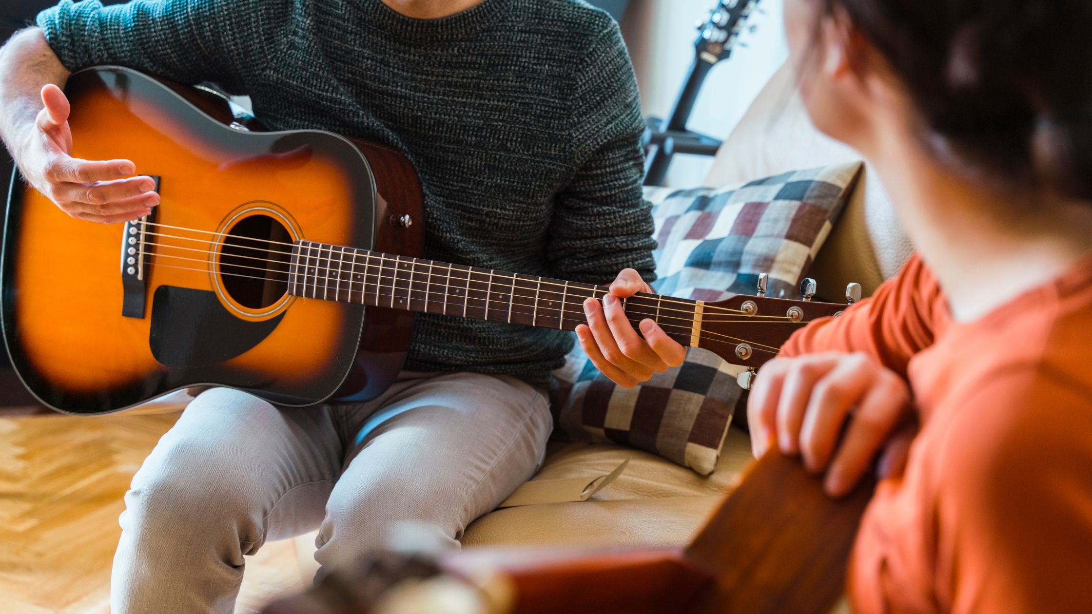 a guitar player teaching a beginner guitarist teaching a best way to learn guitar 