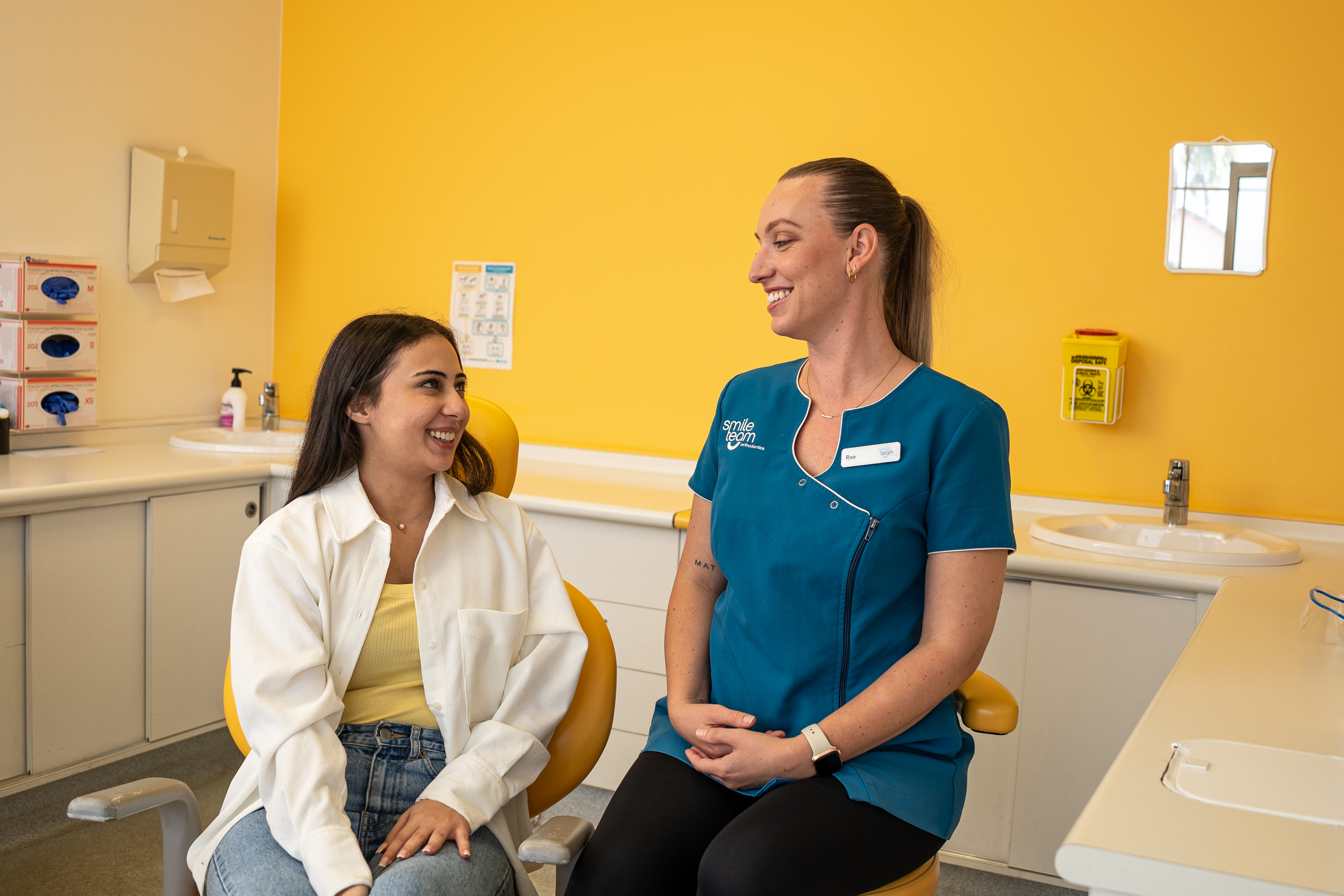 Young woman talking and laughing with dental professional 