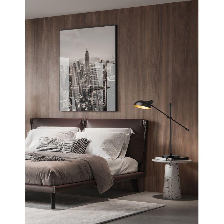 Modern bedroom with a leather bed frame, wooden panelled wall, and black adjustable reading lamps on small side tables.