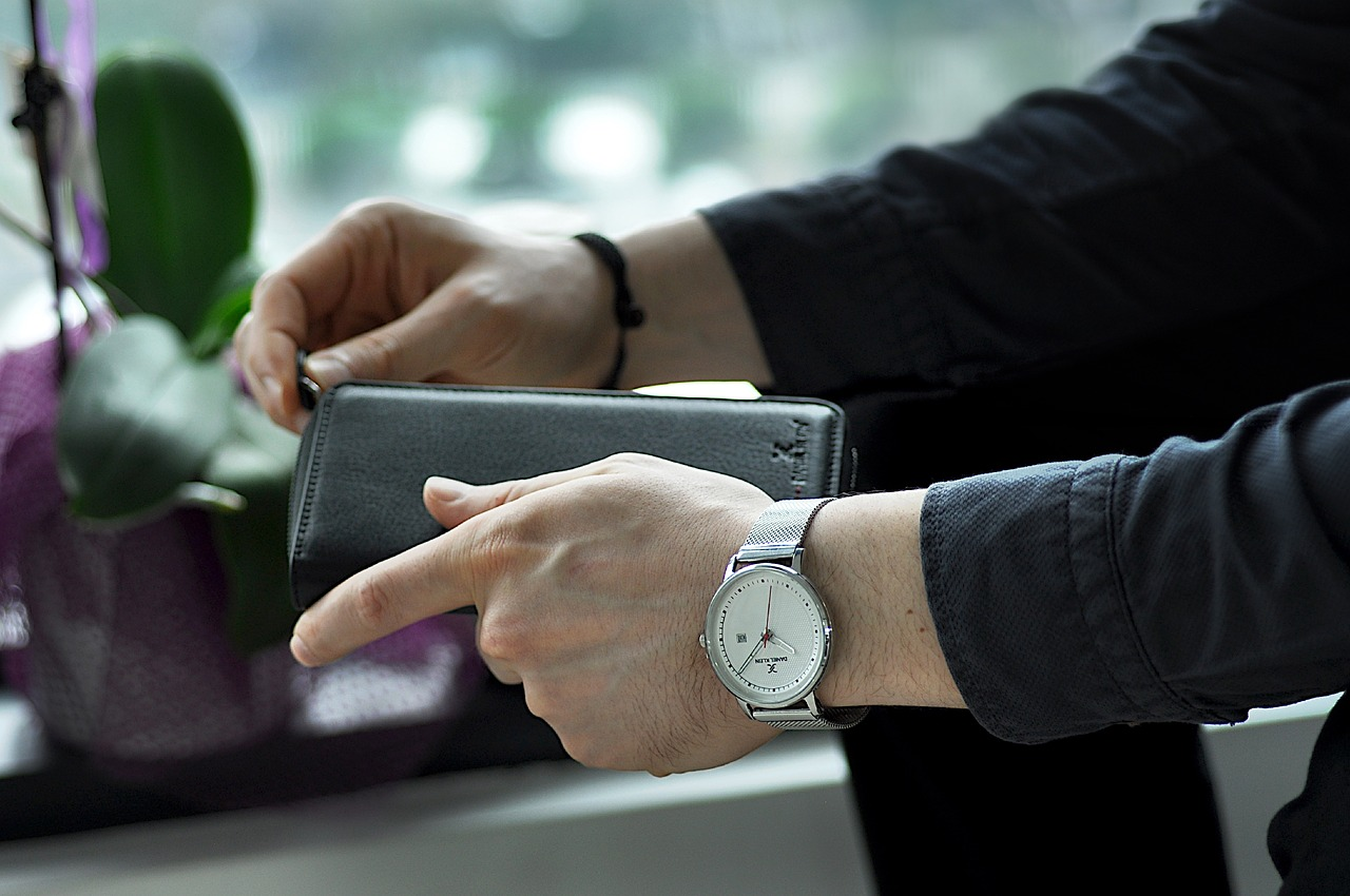 A man holding a sleek wallet in his hand