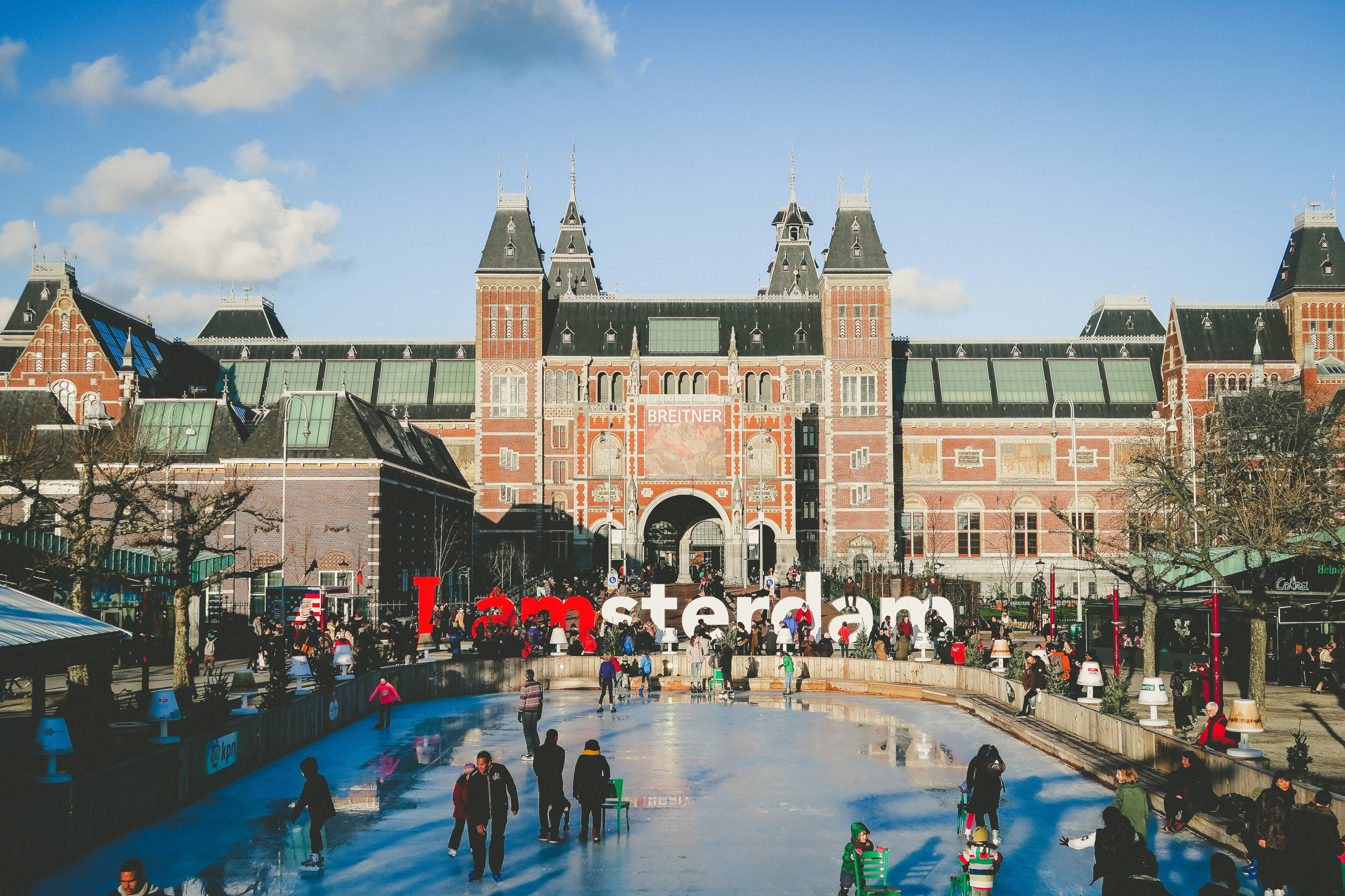 Een foto van het Rijksmuseum in Amsterdam met de bekende ''I amsterdam'' letters ervoor geplaatst.