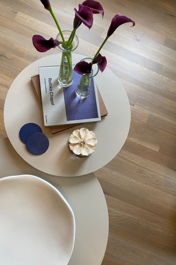 two round tables with coffee table books and flowers
