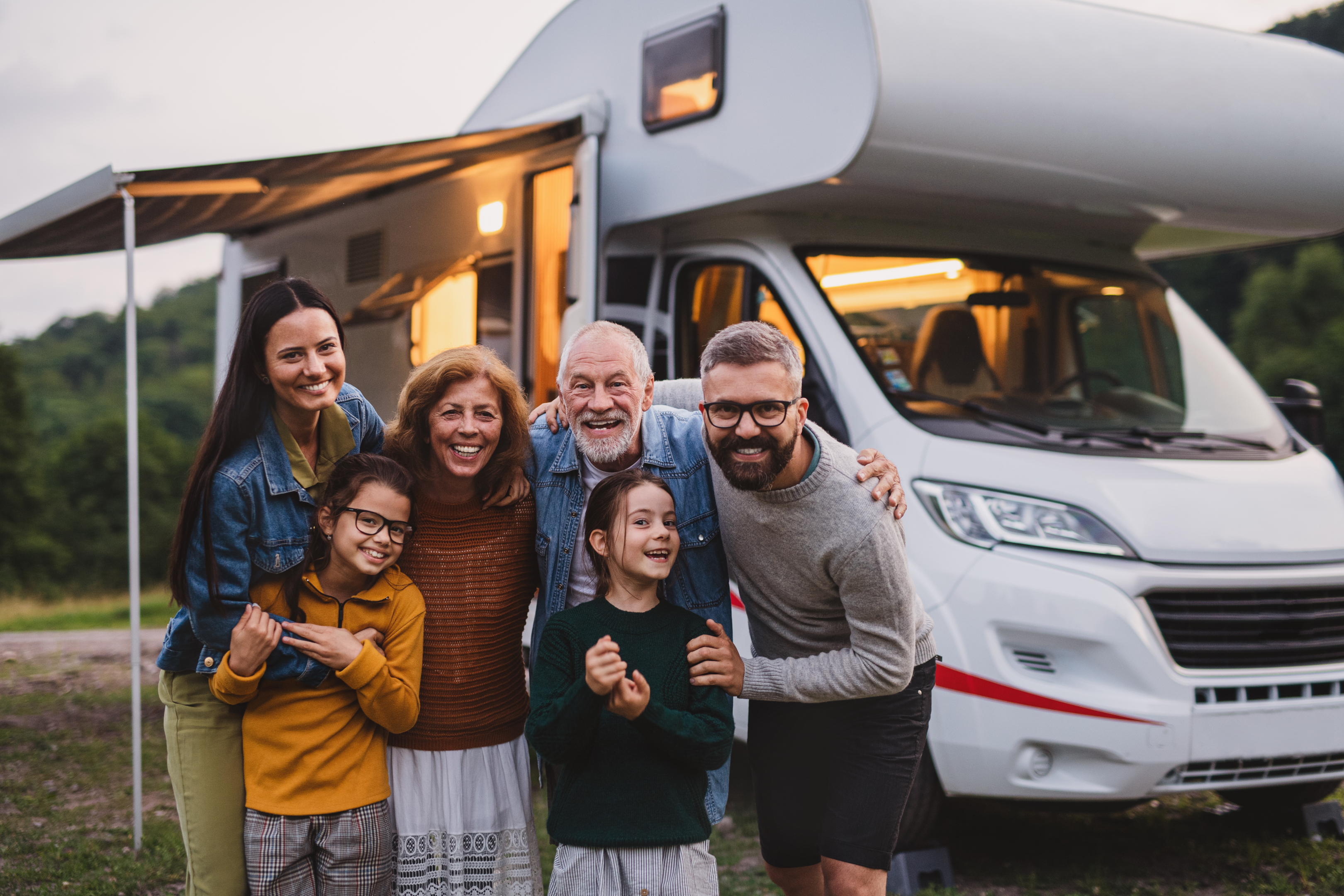 Fröhliche Familie vor ihrem Wohnmobil 