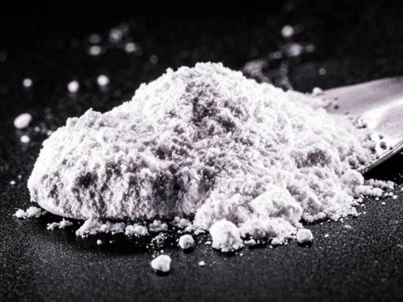 Close-up of a white mineral powder used in bonsai and plant nutrition on a black background.