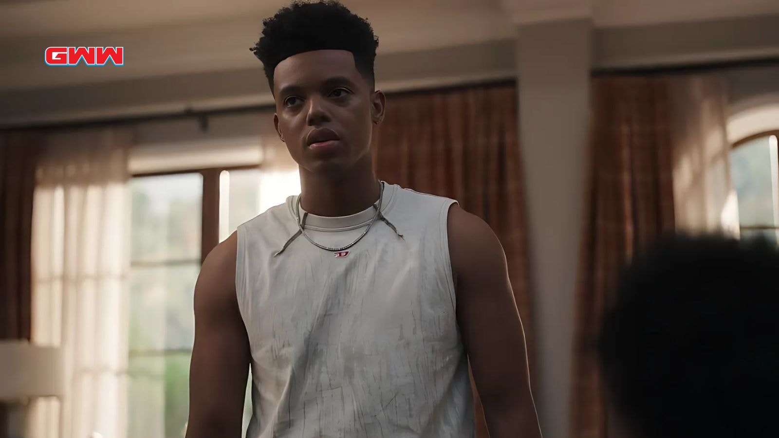 Jabari Banks as Will looking tense in white sleeveless shirt