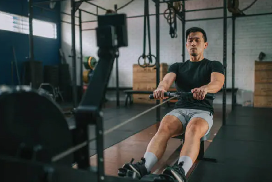 Man using a rowing machine in a gym during an indoor workout session