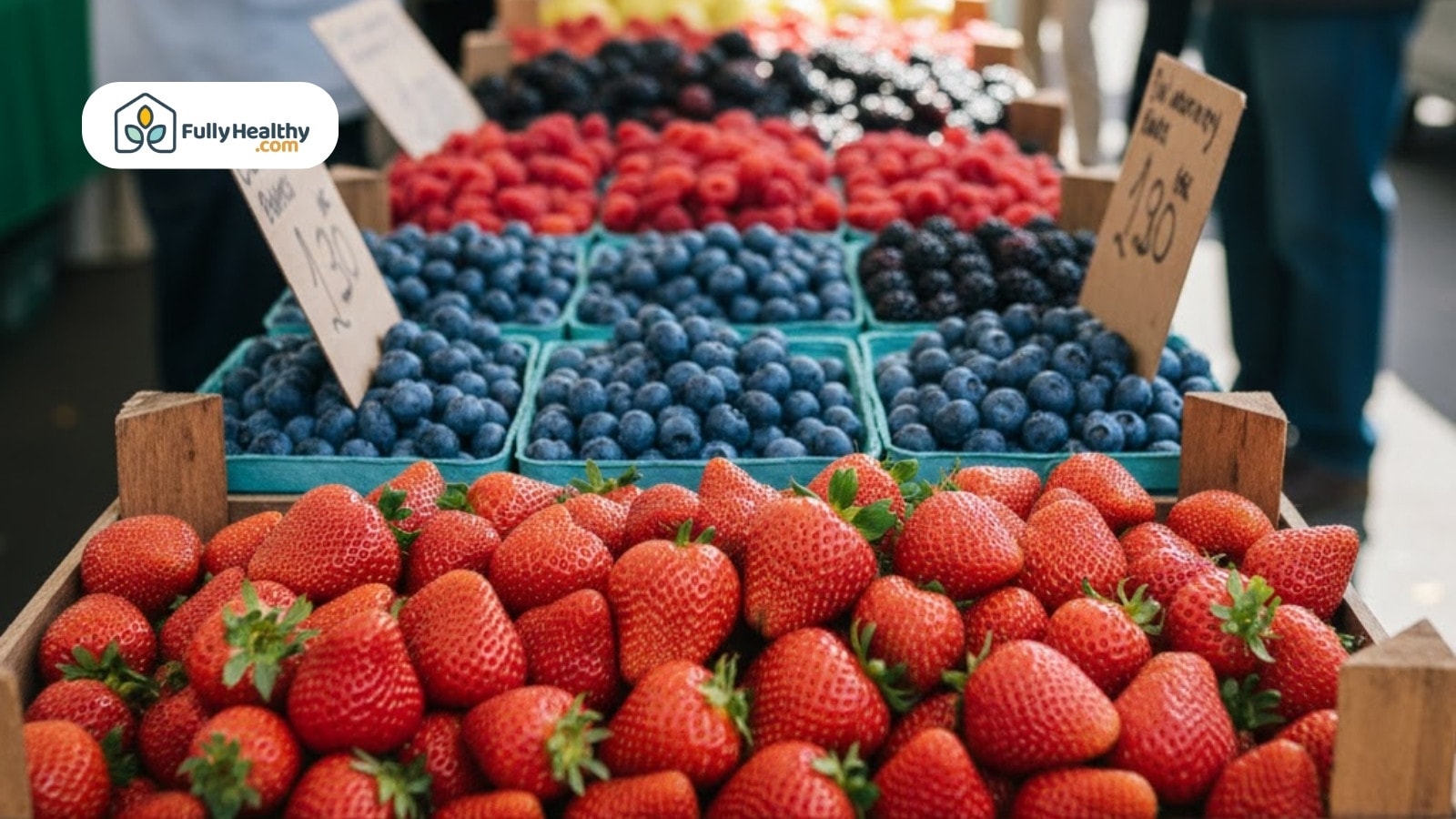 Strawberries and blueberries displayed at farmers market with baskets and price signs