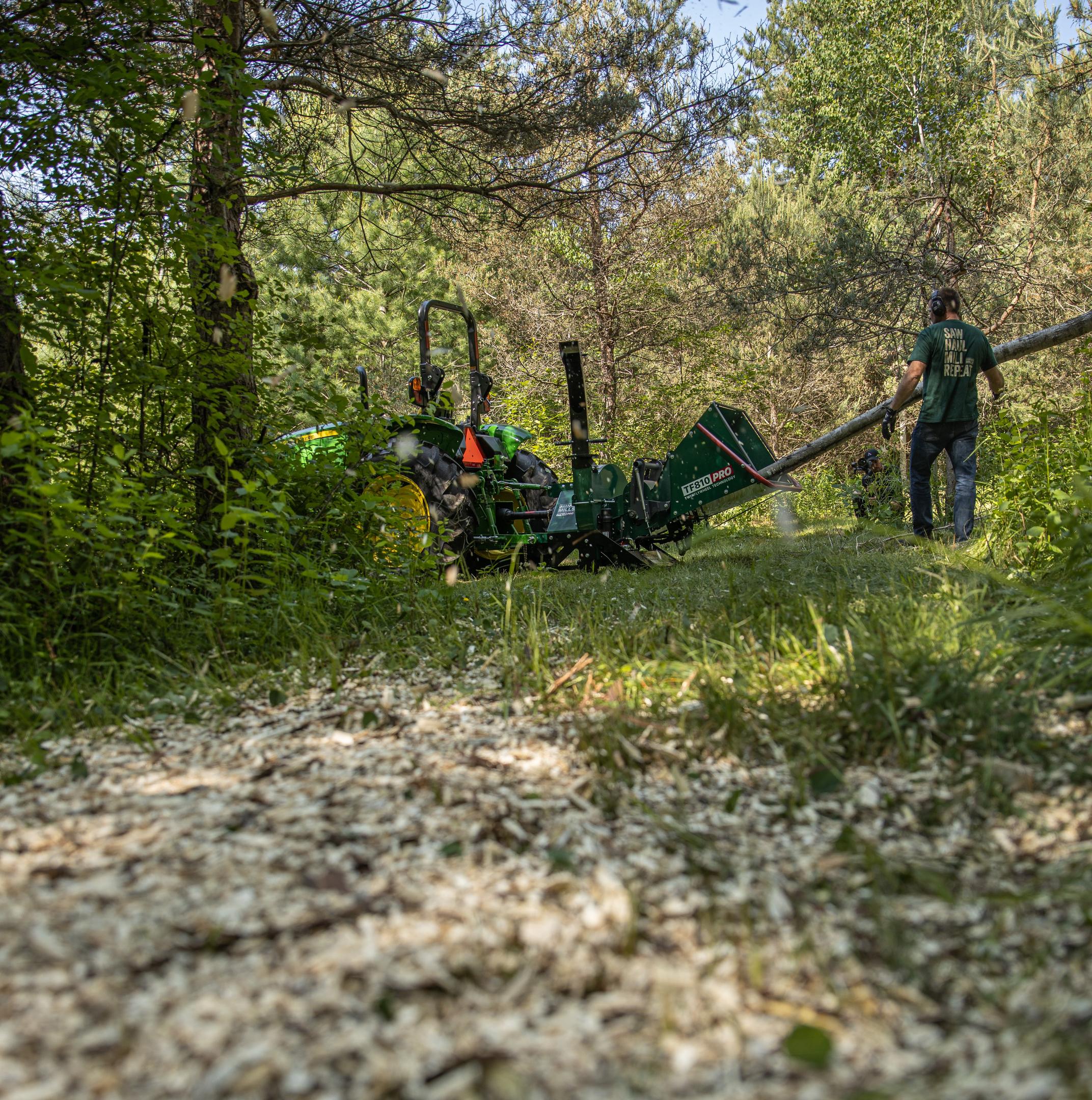 A whole tree being fed into a Woodland Mills wood chipper.