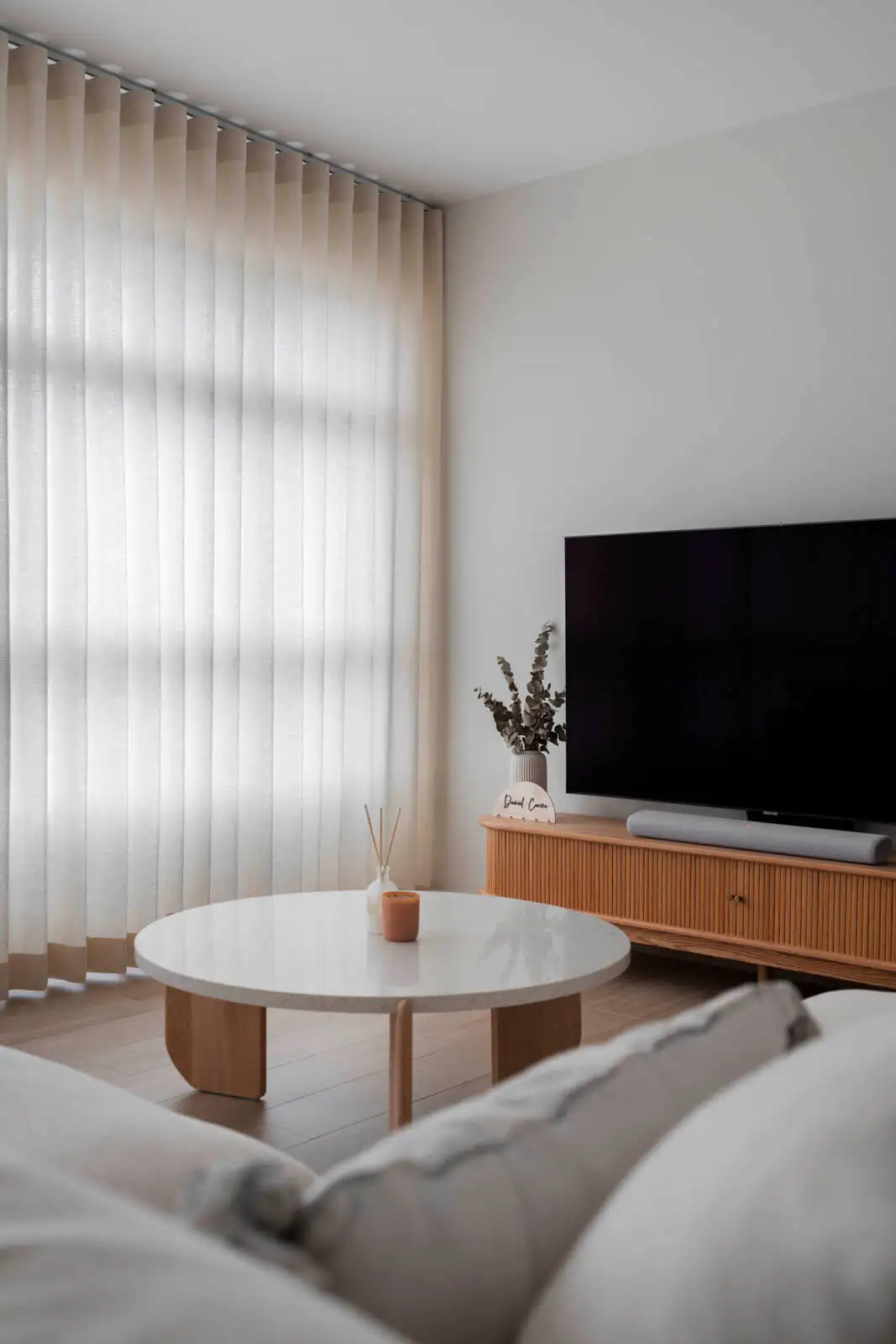 Soft-minimalist HDB living room with sheer drapes and media console