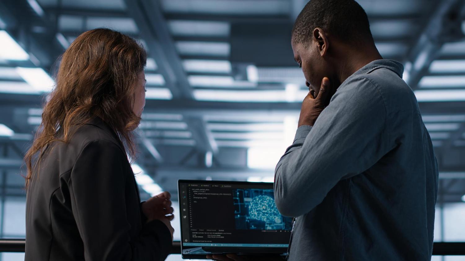 Two ecommerce professionals reviewing supplier data on a computer in an office