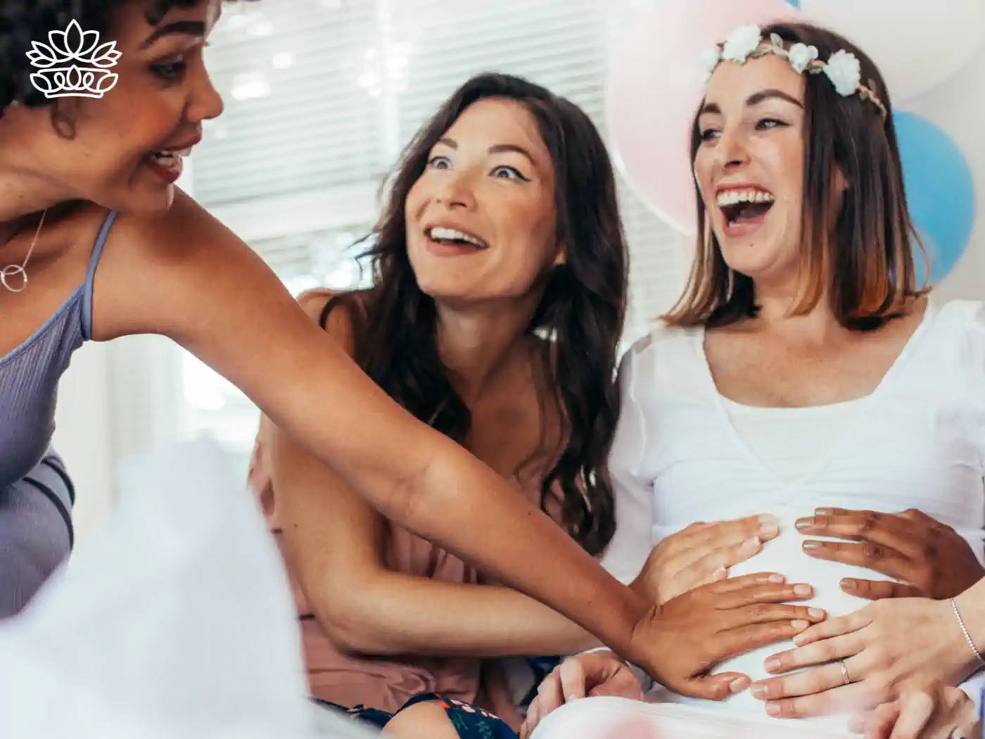 Close-up of women interacting and touching a pregnant woman's belly, surrounded by baby shower decorations and balloons. Fabulous Flowers and Gifts: Baby Shower Flowers Collection
