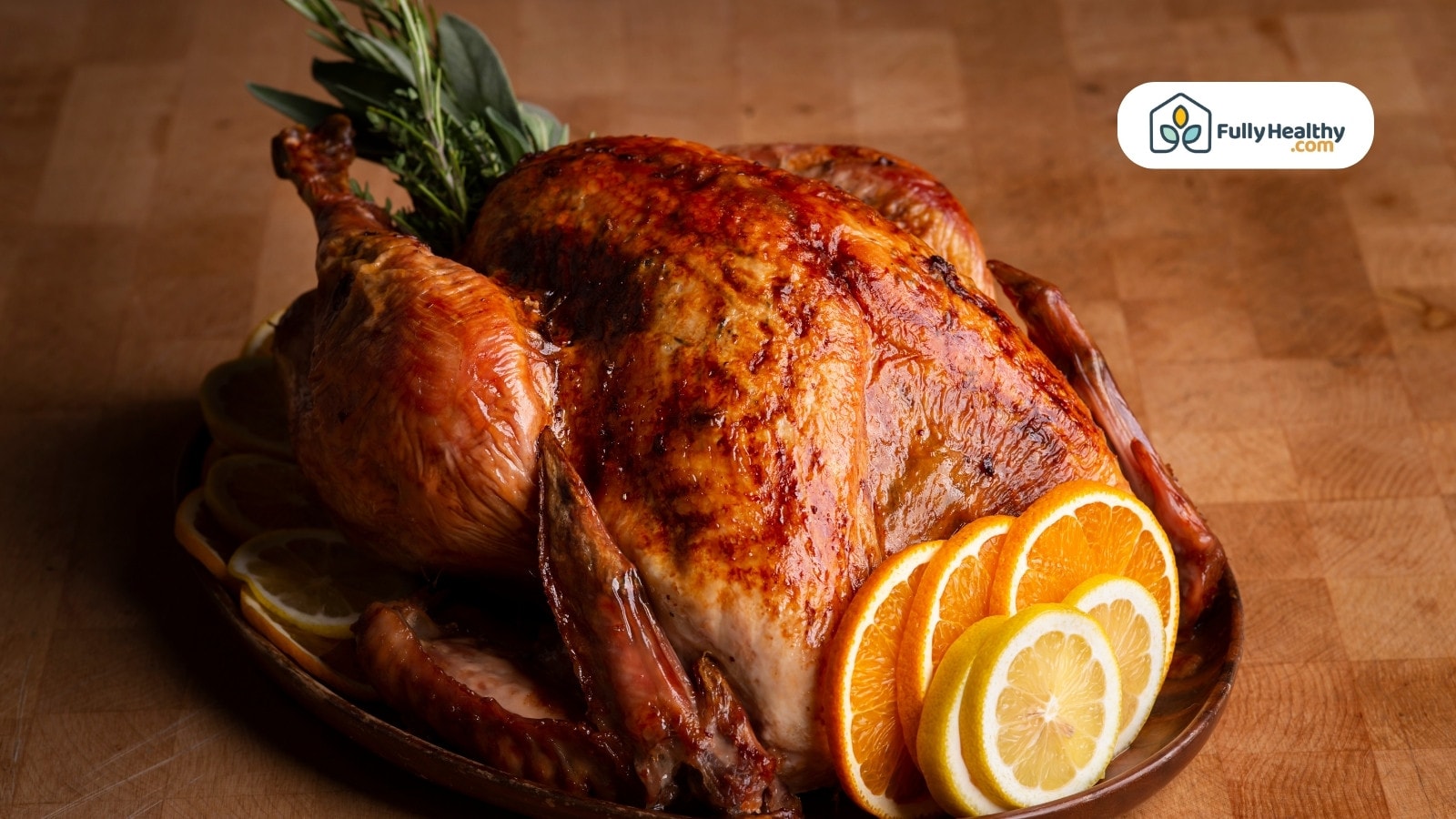Roasted turkey with lemon and orange slices on wooden table
