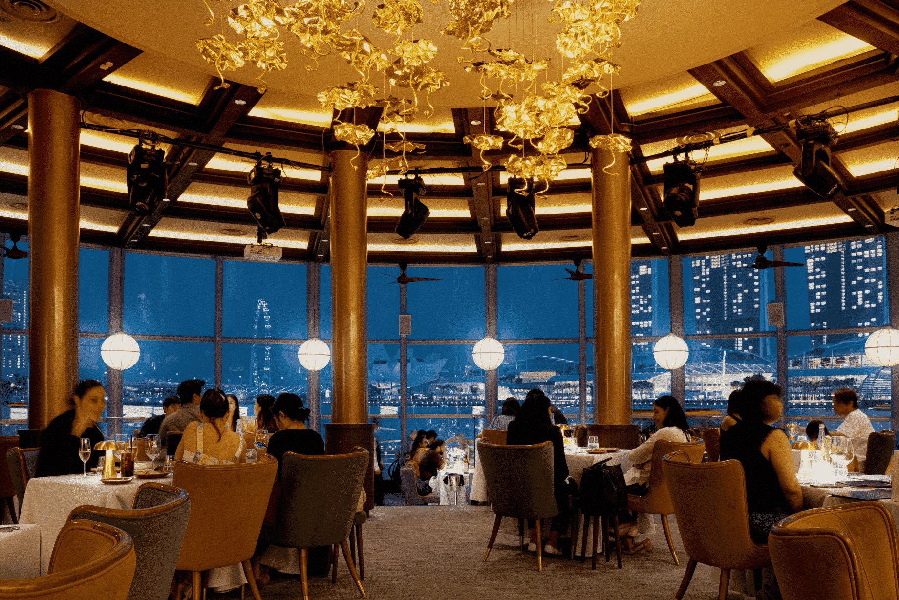 Upscale rooftop dining room in Singapore offering breathtaking views of Marina Bay, Marina Bay Sands, and the Singapore skyline. This romantic restaurant features alfresco balconies, private dining rooms, and panoramic skyline views of downtown Singapore, Marina Bay Financial Centre, Ocean Financial Centre, Customs House, Collyer Quay, Raffles Place, and the Civic District. Ideal for a special dinner or weekday lunch, this Italian restaurant—similar in ambiance to LAVO Italian Restaurant, Artemis Grill, Cé La Vi, and Spago Bar—serves modern Asian cuisine, European classics, seasonal ingredients, small plates, and the freshest seafood including Maine lobster. Guests enjoy signature cocktails during happy hour at the rooftop bar, lounge bar, and club lounge with stunning views of Sentosa Island and Mount Faber Peak. One of the best rooftop restaurants in Singapore for dining with a view, featuring an impressive selection of dishes curated by executive chef Sam Chin and executive chef Oliver Hyde. Book ahead for amazing views, city lights, and a memorable night out in the Marina Bay area.