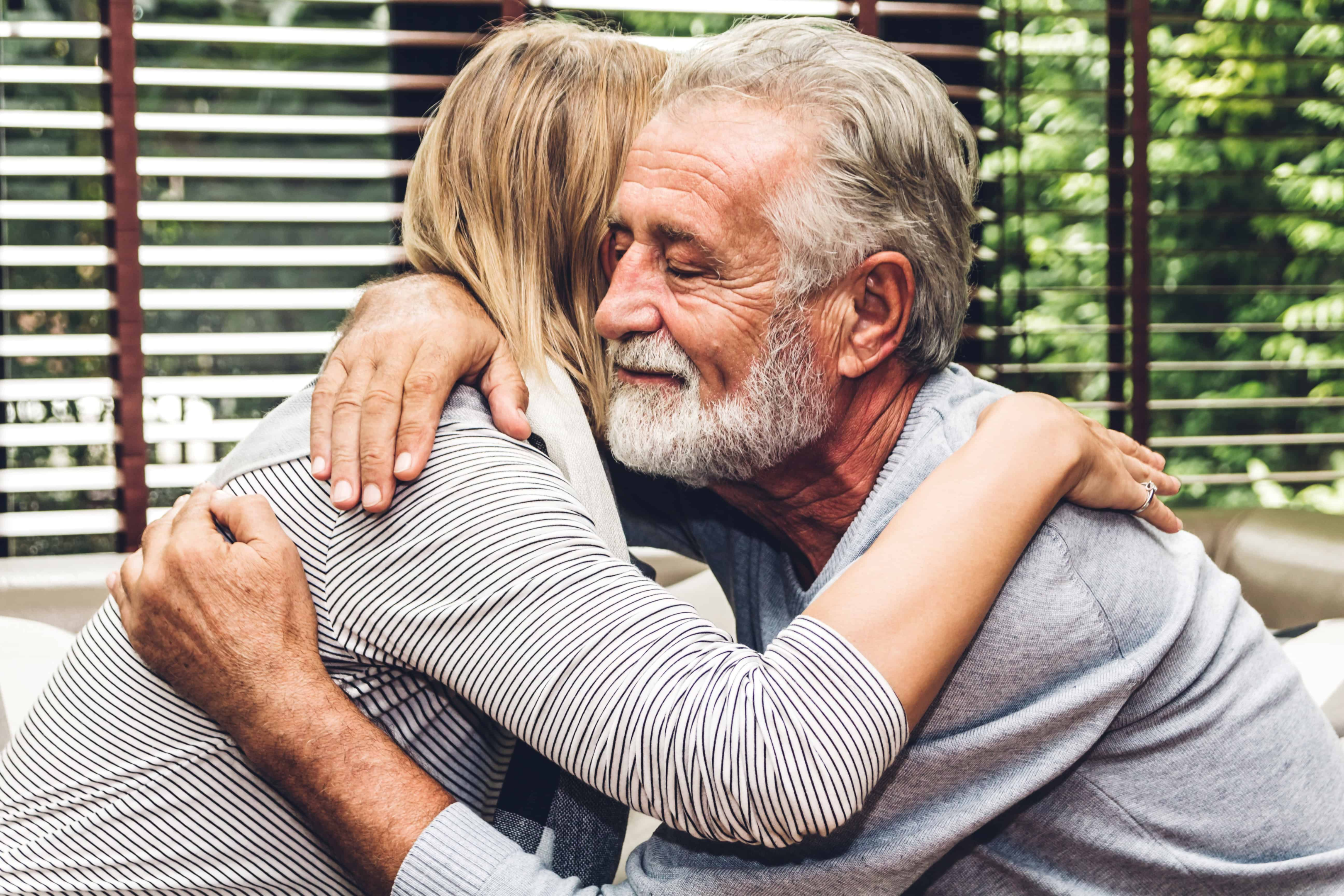 An attractive older couple holding and hugging each other. This couple shows how healing happens in relationships