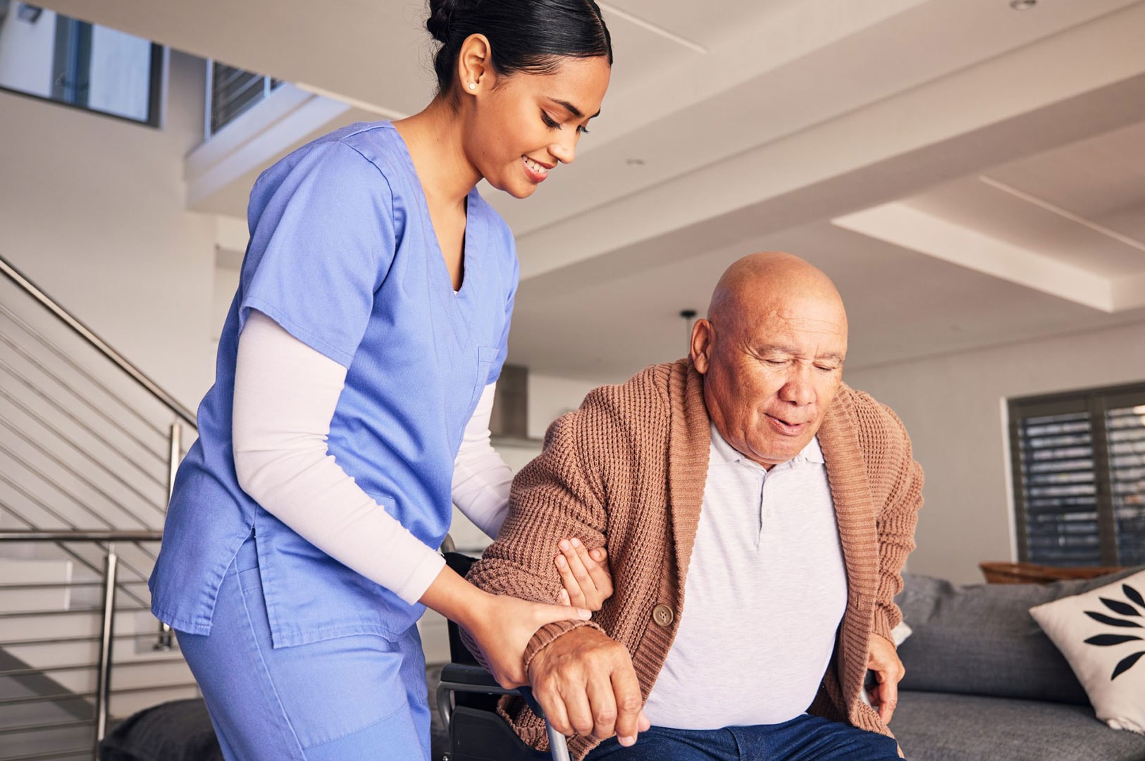 Caregiver assisting an elderly man walking at home.