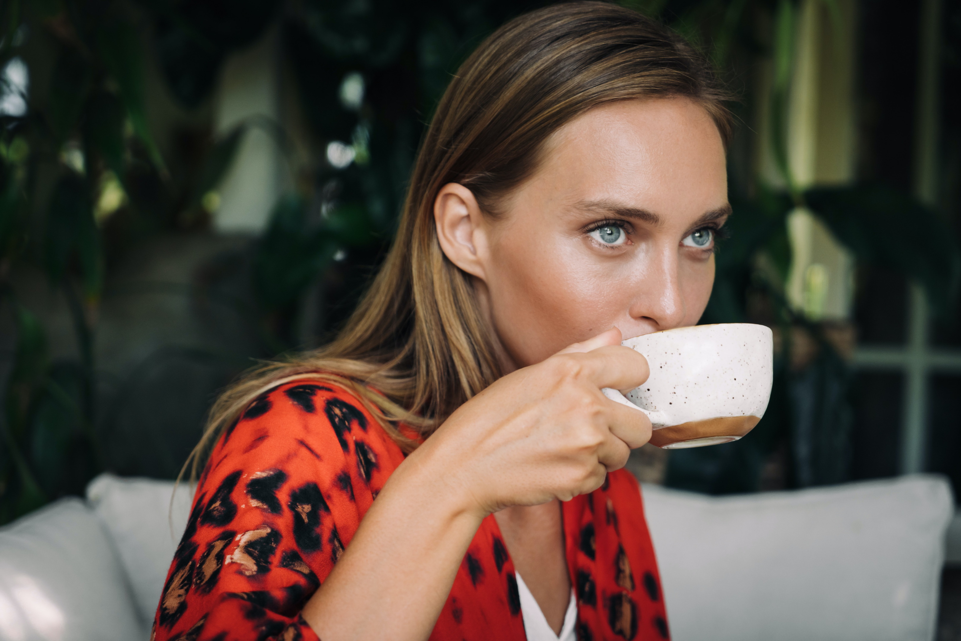 woman in red enjoying her cup of joe