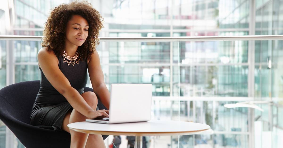 Professional OnlyFans creator researching business tax codes on her laptop in a modern office.