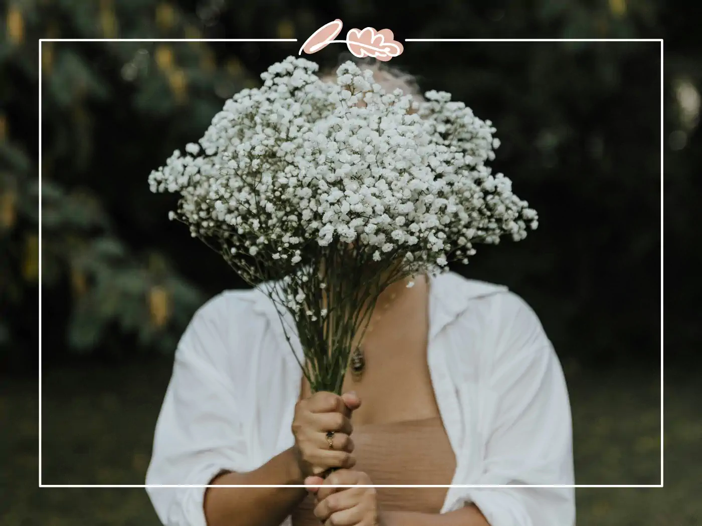 Person holding a large bouquet of white baby's breath flowers in front of their face. Fabulous Flowers and Gifts