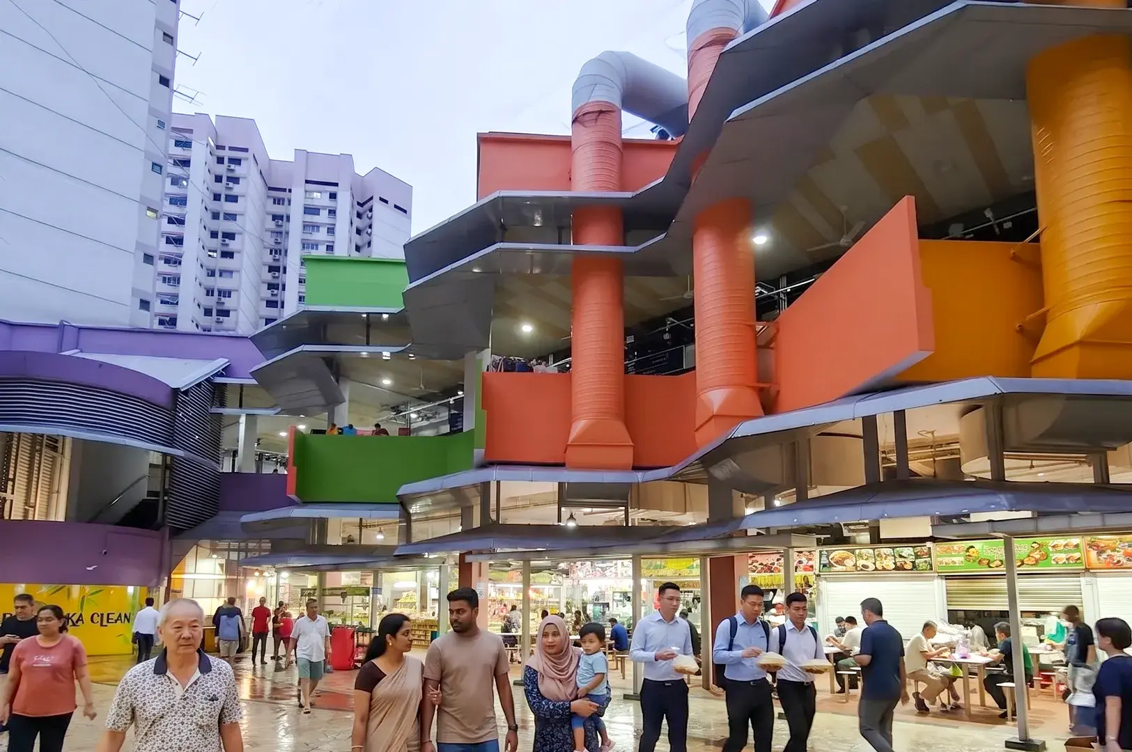 Crowds walking past the colorful exterior of Tekka Centre in Little India, Singapore.