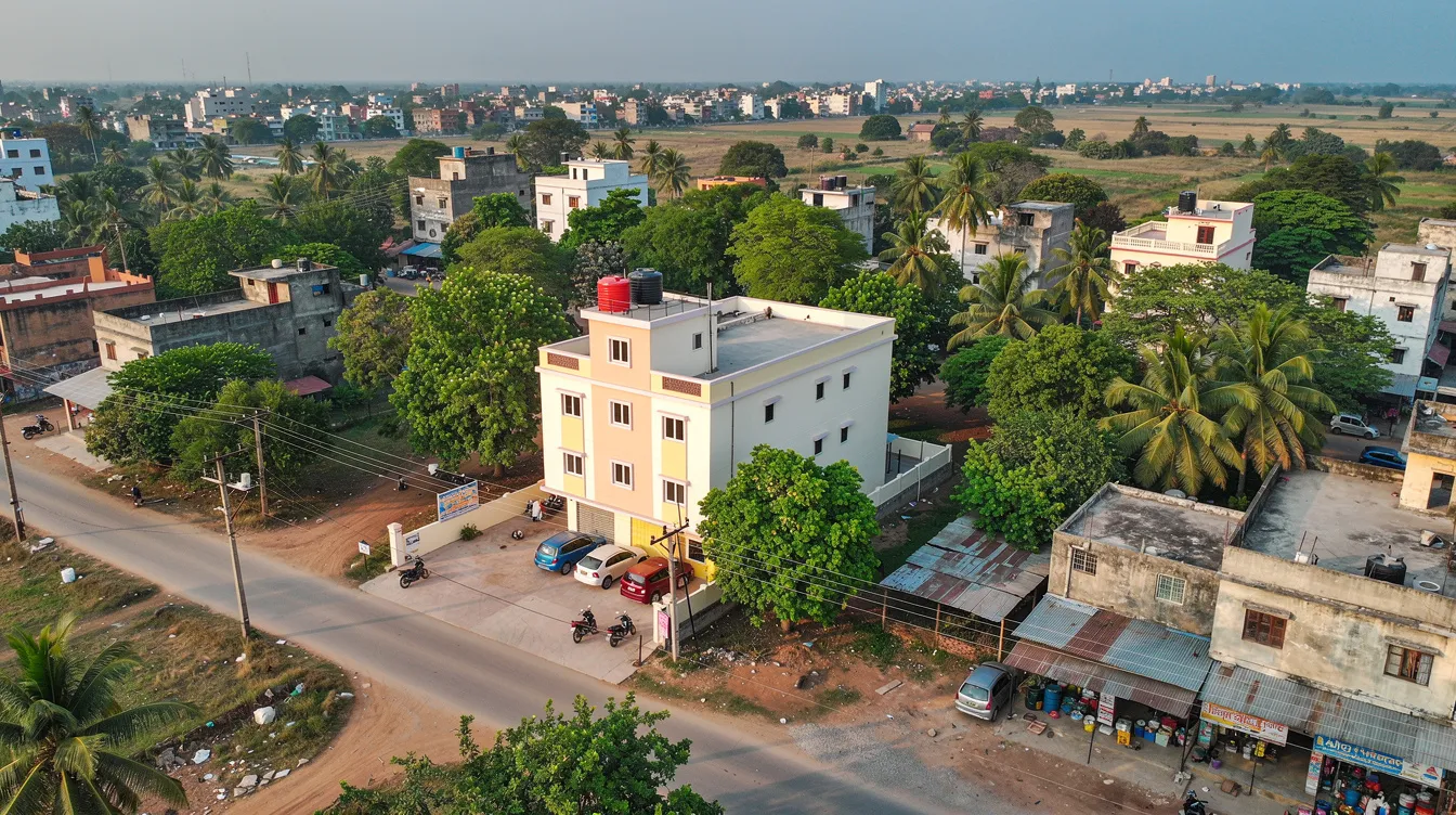 1f66058a 800e 4166 aa26 b1e871c48fa8 An aerial view captures a small Indian hotel property nestled among lush trees in a semi-urban environment, highlighting the hotel's potential for achieving a favorable occupancy rate and managing both fixed and variable costs. This serene setting is ideal for attracting guests and optimizing room sales to enhance the hotel's overall financial health.