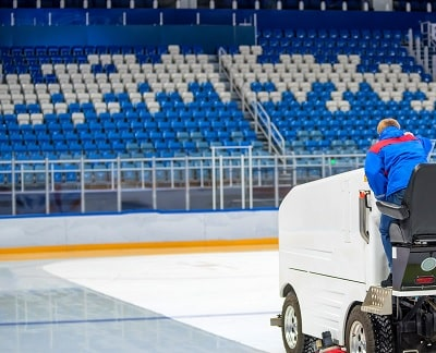 An image of ice rink equipment and amenities, including dasher boards, ice resurfacing machines, and seating areas. These items are important to consider when calculating the cost to build an ice rink that includes the how much does it cost to build an ice rink keyword.