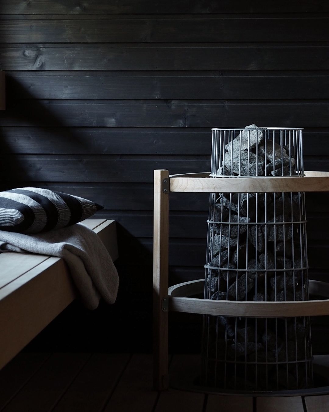 Tummansävyinen sauna luo pehmeän ja tunnelmallisen ympäristön.