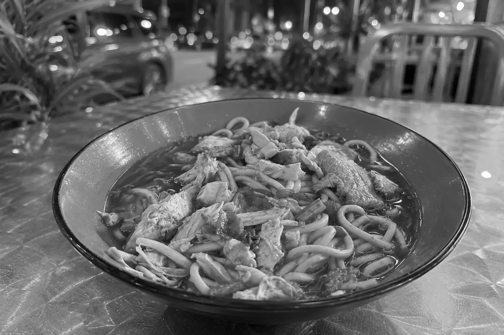 Mee soto combines yellow noodles and shredded chicken in a bowl of fragrant, spice-infused soup.