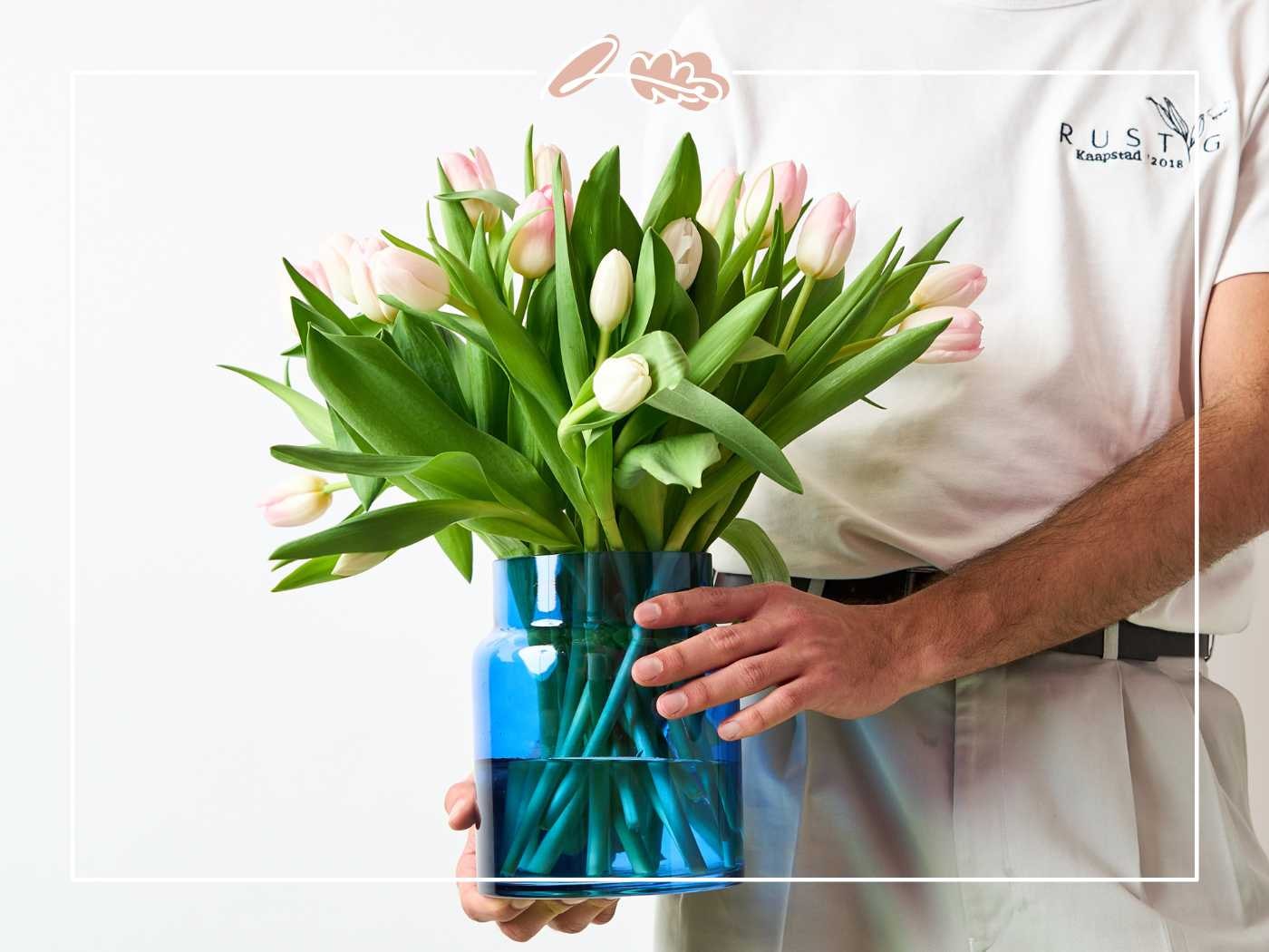 Man holding a vase of pink tulips by Fabulous Flowers and Gifts