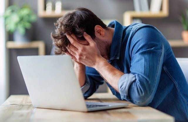 frustrated man, laptop, hands on face