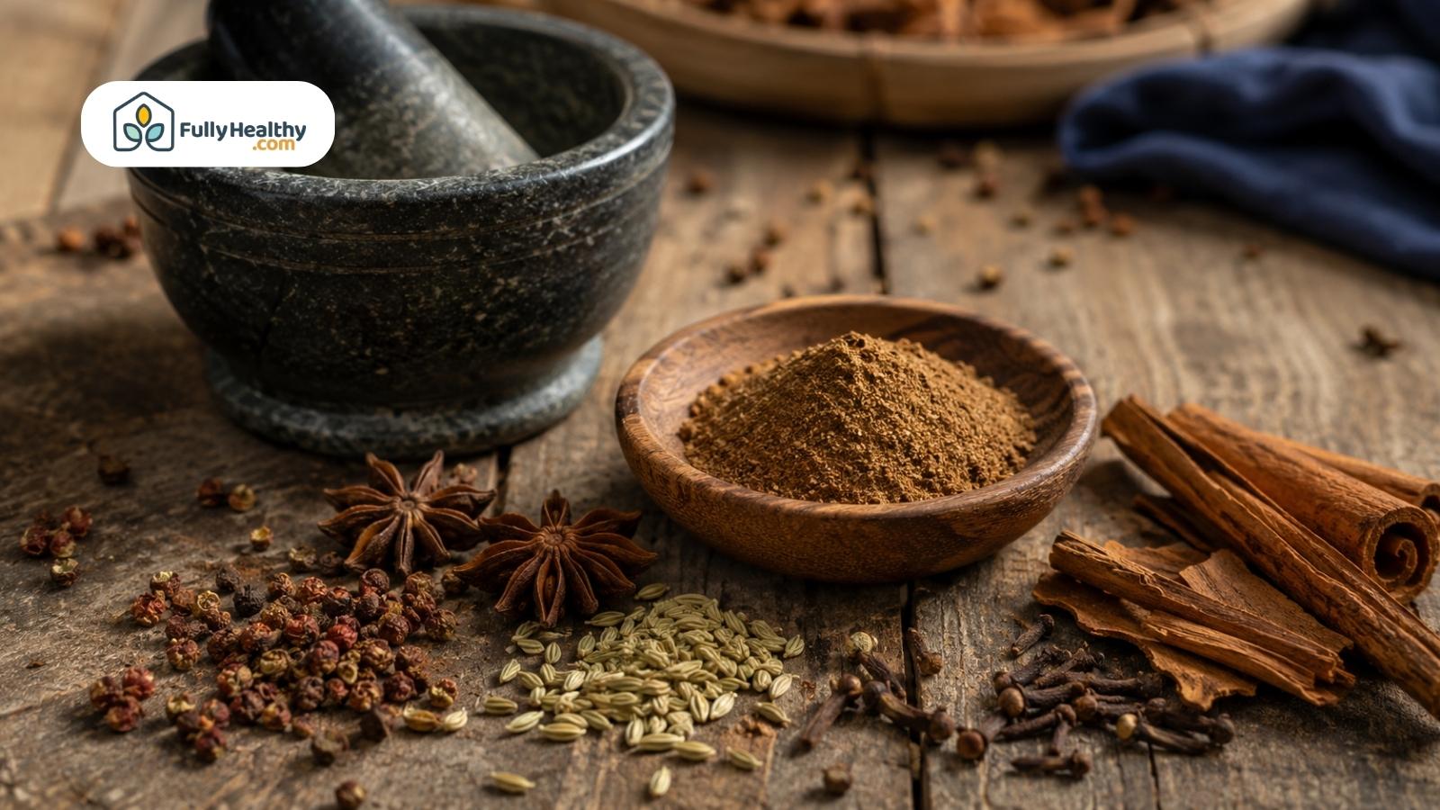 Chinese five-spice powder surrounded by star anise, fennel, cloves, peppercorns, and cinnamon