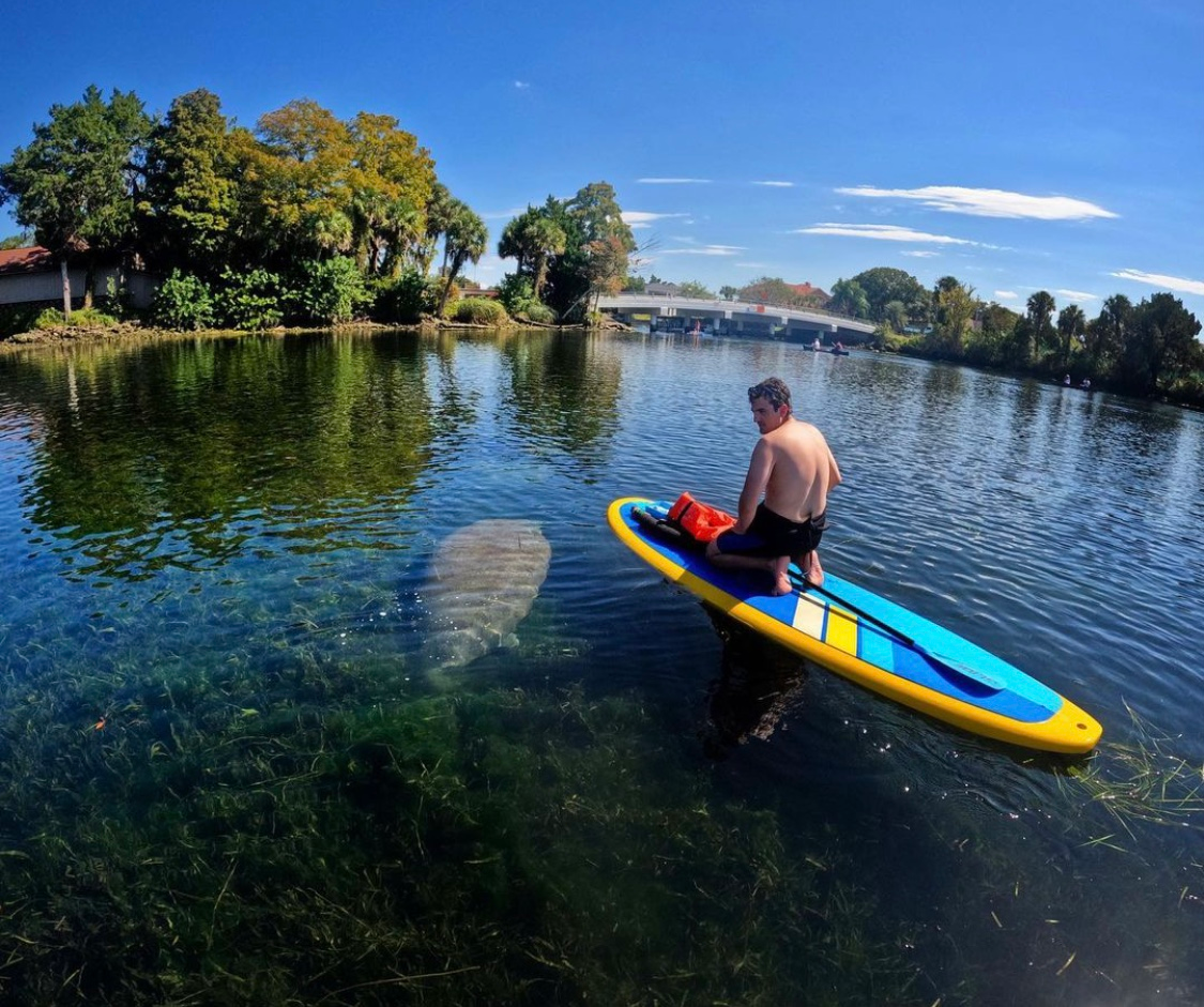 knees slightly bent on inflatable paddle boards on flat water
