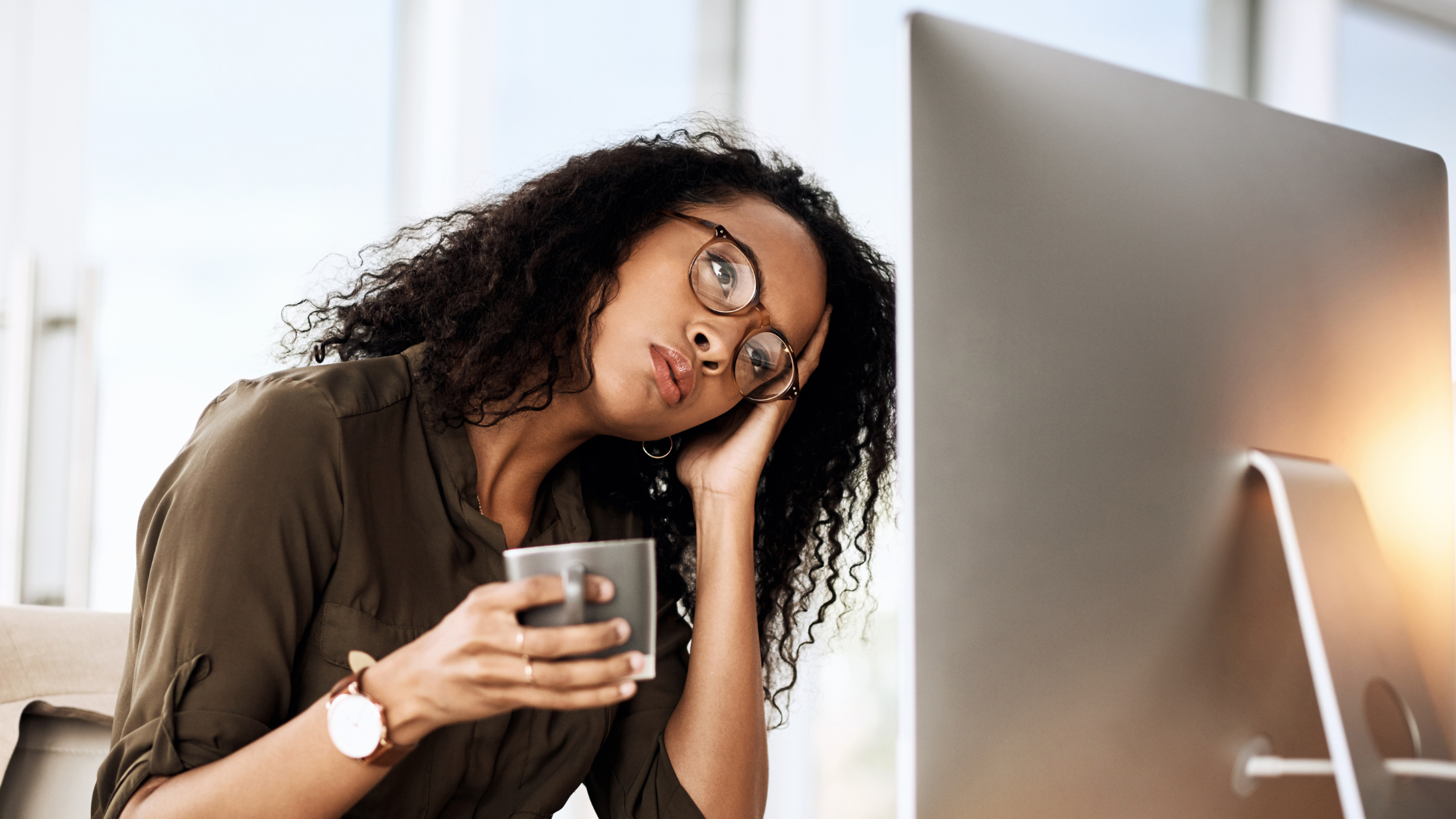 Frustrated woman leaning on her hand while watching a screen, showing the cost and impact of throttling when devices lack high speed Ethernet and dedicated Internet access.
