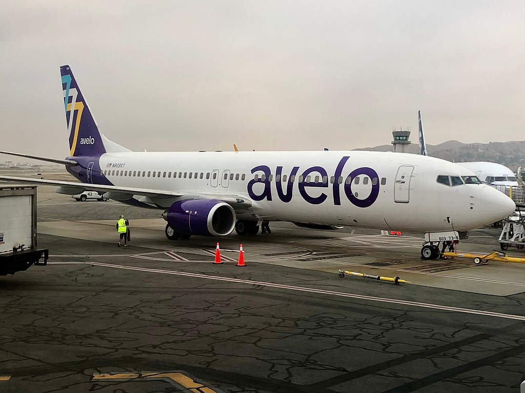 Avelo Airlines aircraft stationed at an airport on a cloudy day.
