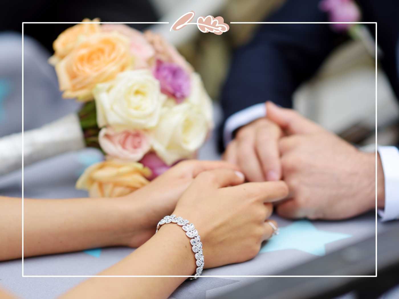 Close-up of the bride and groom holding hands, with a stunning bouquet of pastel roses on the table. Fabulous Flowers and Gifts.