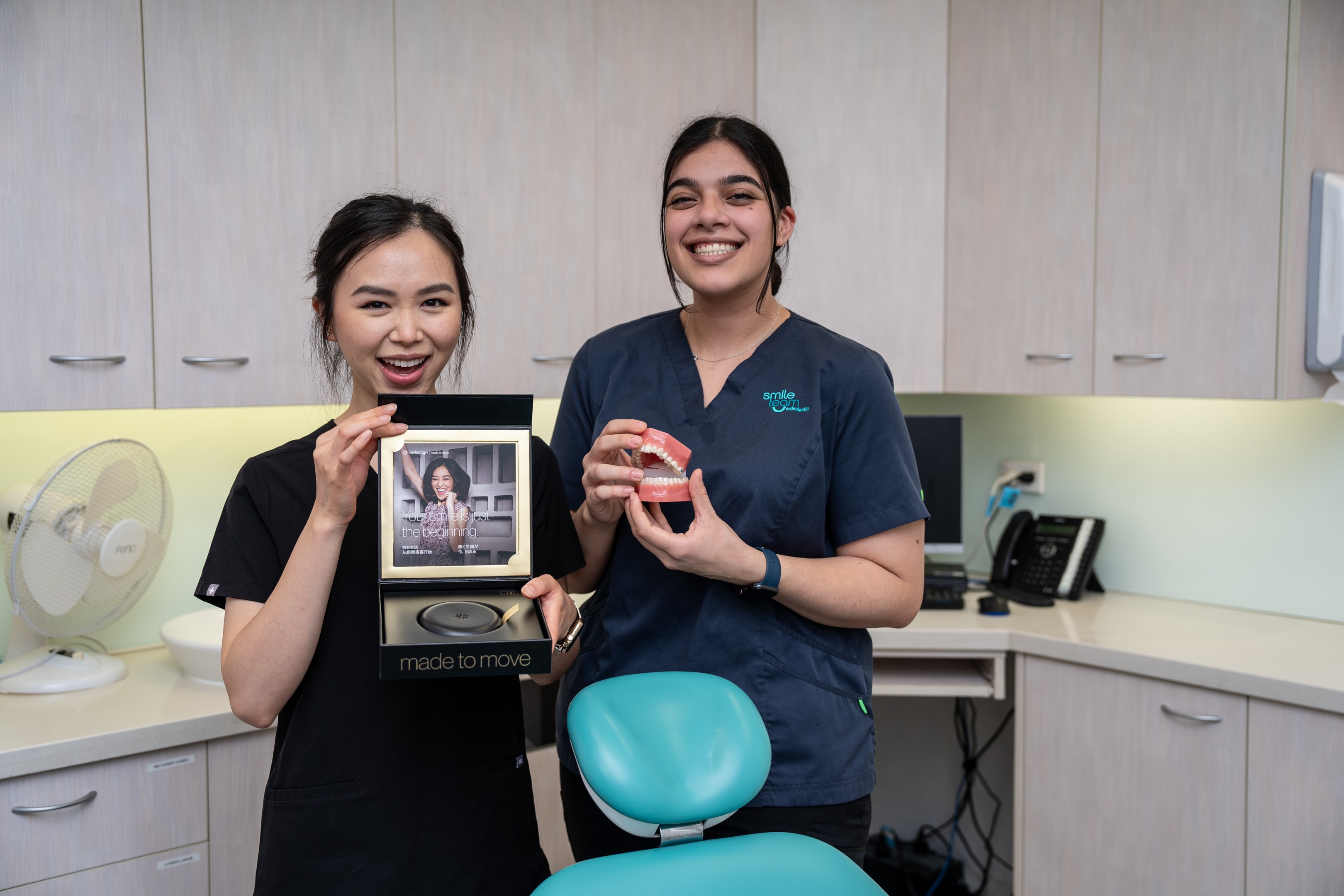 young nurses holding Invisalign box and dental model with braces on